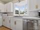 Kitchen featuring stainless appliances, white cabinets, gold hardware and a bay window over the sink at 616 W Marion St, Shelby, NC 28150