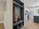 A mudroom with coat rack opens to the kitchen featuring white cabinets, stainless appliances, and marble backsplash at 616 W Marion St, Shelby, NC 28150