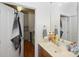 Bathroom featuring a wooden vanity, mirror, and an open door view into the kitchen at 630 Calvert St # 410, Charlotte, NC 28208