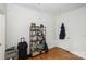 Bedroom with hardwood floors, a shelving unit with decor, and a door leading to the hallway at 630 Calvert St # 410, Charlotte, NC 28208