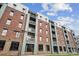 Exterior view of a brick apartment building with balconies and large windows against a blue sky at 630 Calvert St # 410, Charlotte, NC 28208