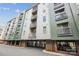View of a modern apartment building with balconies and gated parking against a blue sky at 630 Calvert St # 410, Charlotte, NC 28208
