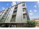 Modern apartment building with balconies and gated parking is showcased against a bright blue sky at 630 Calvert St # 410, Charlotte, NC 28208