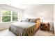 Bright bedroom featuring a wooden bed frame, large window with natural light, and neutral color scheme at 6507 Revolutionary Trl, Charlotte, NC 28217