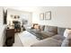 Cozy living room with a large gray sectional sofa, patterned rug, and a workstation by the bright window at 6507 Revolutionary Trl, Charlotte, NC 28217