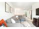 Comfortable living area with gray sectional, decorative pillows, wall art, and view into bedroom hallway at 6507 Revolutionary Trl, Charlotte, NC 28217