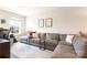 Inviting living room featuring a gray sectional, modern decor, and bright natural light from the window at 6507 Revolutionary Trl, Charlotte, NC 28217