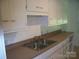 Functional kitchen featuring neutral countertops, white cabinets, and a stainless steel double sink at 761 Henry Rhodes Rd, Lincolnton, NC 28092