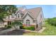 Inviting townhome with tidy lawn, brick accents, and lush landscaping surrounding the front at 825 Rock Lake Gln, Fort Mill, SC 29715