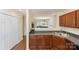 Kitchen area with wooden cabinets and stainless sink, and doorway view into the living room at 825 Rock Lake Gln, Fort Mill, SC 29715