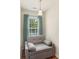A nook featuring a gray sofa, a hanging light fixture, and a window with blinds and light blue curtains at 825 Rock Lake Gln, Fort Mill, SC 29715