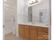 Bright bathroom with double sinks, wood cabinets, and a large mirror at 8465 Olde Troon Dr, Charlotte, NC 28277