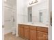Neutral bathroom featuring a long vanity with storage beneath and a shower with accessible features at 8465 Olde Troon Dr, Charlotte, NC 28277