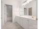 Bright bathroom featuring double sinks, white cabinets, and tile floors at 8465 Olde Troon Dr, Charlotte, NC 28277