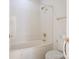 Cozy bathroom featuring marble style wall, a shower-tub combo with gold fixtures, and a white toilet at 8465 Olde Troon Dr, Charlotte, NC 28277
