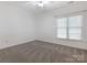 A bright carpeted bedroom with a ceiling fan and window letting in plenty of natural light at 8465 Olde Troon Dr, Charlotte, NC 28277