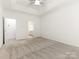 Large bedroom features neutral carpet and trim, offering a view of the attached bathroom at 8465 Olde Troon Dr, Charlotte, NC 28277