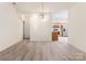 Open dining area featuring wood floors, a modern chandelier, and easy access to the kitchen at 8465 Olde Troon Dr, Charlotte, NC 28277