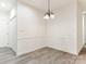 Empty dining area with wood floors, a simple chandelier, and neutral walls, ready for personalization at 8465 Olde Troon Dr, Charlotte, NC 28277