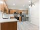 Well-equipped kitchen with stainless steel appliances, white countertops, and oak cabinetry at 8465 Olde Troon Dr, Charlotte, NC 28277