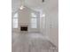 Living room with vaulted ceilings, fireplace, lots of light, and modern gray floors at 8465 Olde Troon Dr, Charlotte, NC 28277