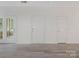 Bright living room with fresh white paint, multiple doors, and modern gray floors at 8465 Olde Troon Dr, Charlotte, NC 28277