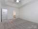 Spacious carpeted main bedroom featuring tray ceilings, attached bathroom, and neutral walls at 8465 Olde Troon Dr, Charlotte, NC 28277