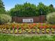 Welcoming entrance sign to the Village of Troon, surrounded by vibrant flower beds at 8465 Olde Troon Dr, Charlotte, NC 28277
