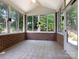 Sunroom with brick walls, tile floors, ceiling fan and many windows offering backyard views at 8465 Olde Troon Dr, Charlotte, NC 28277
