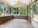 Bright sunroom featuring brick walls, tiled floors, and multiple large windows offering ample natural light at 8465 Olde Troon Dr, Charlotte, NC 28277