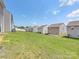 Spacious backyard view highlighting lush green grass and neighboring homes, perfect for outdoor activities and community at 9136 Creedmore Hills Dr, Charlotte, NC 28214