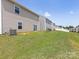 This backyard view showcases green lawn space, neighboring homes, and sliding glass doors offering easy indoor-outdoor access at 9136 Creedmore Hills Dr, Charlotte, NC 28214
