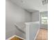 A naturally lit hallway features wood flooring and a staircase leading to the upper level at 9136 Creedmore Hills Dr, Charlotte, NC 28214