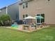 View of backyard with patio set, umbrellas, and play equipment at 1008 Whipcord Dr, Waxhaw, NC 28173