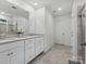Bathroom with double vanity, white cabinets, white walls, tile floor, large mirror and neutral shower curtain at 1008 Whipcord Dr, Waxhaw, NC 28173