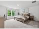 Bright bedroom featuring a large window, neutral decor, carpeted floor and a comfortable bed at 1008 Whipcord Dr, Waxhaw, NC 28173