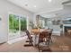 Light-filled dining area with access to patio and view of living room with fireplace at 1008 Whipcord Dr, Waxhaw, NC 28173