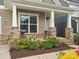 Charming front porch with stone pillars and garden with flowers creates an inviting entrance to the home at 1008 Whipcord Dr, Waxhaw, NC 28173