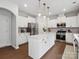 Bright kitchen featuring white cabinets, stainless steel appliances, dark wood floors and center island at 1008 Whipcord Dr, Waxhaw, NC 28173