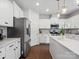 Bright kitchen with stainless steel appliances, dark wood floors, white cabinets, and a large island at 1008 Whipcord Dr, Waxhaw, NC 28173