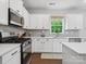 Modern kitchen with stainless steel appliances, white cabinets, and quartz countertops at 1008 Whipcord Dr, Waxhaw, NC 28173