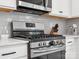 Kitchen with stainless steel range, gray subway tile backsplash, white cabinets, and quartz countertops at 1008 Whipcord Dr, Waxhaw, NC 28173