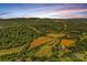 Stunning aerial view of a sprawling property with rolling hills, lush greenery, and clear blue skies at 1043 Linneys Mill Rd, Union Grove, NC 28689
