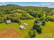Expansive aerial view of a rural property featuring well-maintained lawns, outbuildings and verdant trees at 1043 Linneys Mill Rd, Union Grove, NC 28689