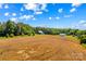 Expansive aerial view of a property with golden field, barns, and mountain vistas at 1043 Linneys Mill Rd, Union Grove, NC 28689