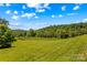 Expansive view of a lush green field with trees and mountains in the distance at 1043 Linneys Mill Rd, Union Grove, NC 28689