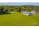 Aerial view of property with large green field, house and garages at 1043 Linneys Mill Rd, Union Grove, NC 28689