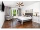 Bedroom showcasing natural light, hardwood floors, tray ceilings, a ceiling fan, and gray decor at 11225 Black Brant Ln, Charlotte, NC 28278