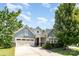Well-maintained home with a two-car garage, complemented by lush landscaping and craftsman-style architectural details at 11225 Black Brant Ln, Charlotte, NC 28278