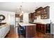 Modern kitchen features an island with seating, pendant lighting, stainless steel appliances, and dark wood cabinetry at 11225 Black Brant Ln, Charlotte, NC 28278